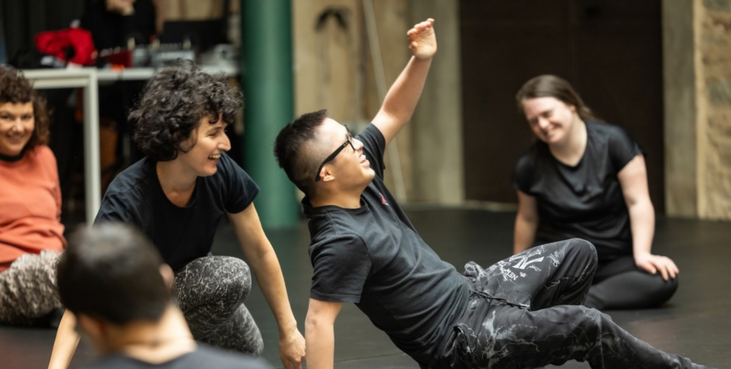 Laboratorio di danza inclusiva con persone con e senza disabilità impegnate in esercizi di movimento, in un clima sereno e partecipato.